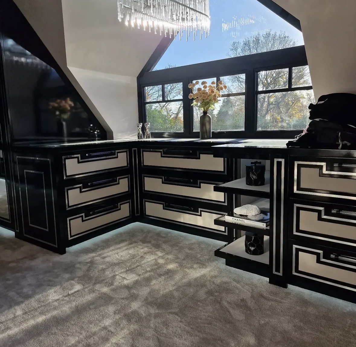 Bespoke dressing room with high-gloss black and ivory drawer fronts, stone tops and open display shelving